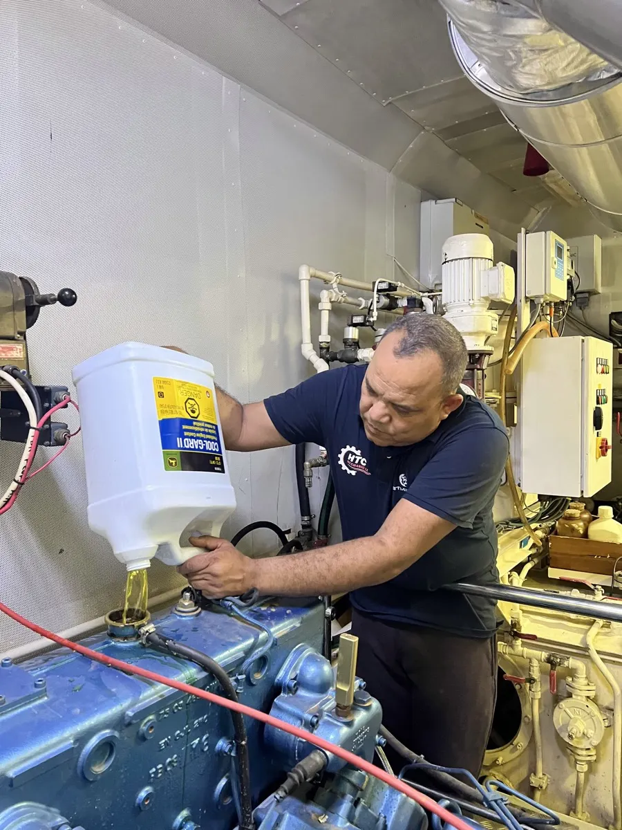 Mecánico de HTC Mechanic revisando un motor marino diésel